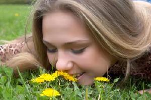 pretty girl smells dandelion